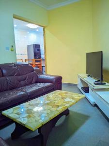 a living room with a couch and a table with a television at New Park Resort in Mahajanga