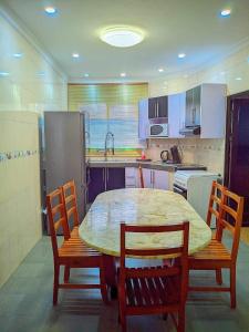 a kitchen with a table and chairs and a kitchen with white cabinets at New Park Resort in Mahajanga +62 photos