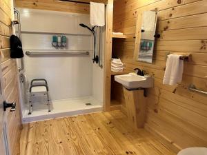 a bathroom with a shower with a sink and a toilet at Cowan Creek Lodges in Centre +33 photos