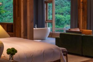 una camera con vasca e letto e un bagno di Ethnic Hundred-years Elysian Culture&Art Scholar Resorts a Zhangjiajie