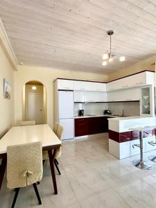 een keuken en eetkamer met een tafel en stoelen bij Golden Berden Boutique Apart-Hotel in Çukë