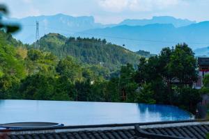 una vista di un lago con le montagne sullo sfondo di Ethnic Hundred-years Elysian Culture&Art Scholar Resorts a Zhangjiajie