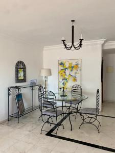 a dining room with a glass table and chairs at Dar sam in Tangier
