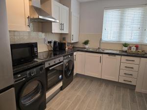 a kitchen with a washer and dryer in it at Dreams and Homes in Dublin- Entire home in Hartstown