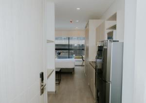 a hallway with a refrigerator and a bed in a room at Apartamento moderno en Usaquen, con Coworking y a pasos de la Fundación Santa Fe in Bogotá