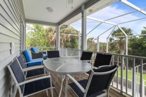 a screened porch with a table and chairs at Halliday in Sanibel