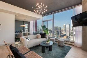 a living room with a couch and a large window at 2 Storey Penthouse Panoramic Views Parking Stampede in Calgary