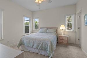 a white bedroom with a bed and two windows at Halliday in Sanibel +44 photos