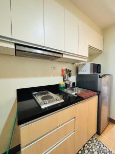una cocina con fregadero y refrigerador en Nature Lovers Paradise in Iloilo City - Cozy Condo Rental, en Iloilo City