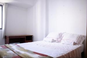 a bedroom with a bed with a table and a window at Sunflower in João Pessoa +3 photos
