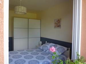 Schlafzimmer mit einem Bett mit einer blauen und weißen Bettdecke in der Unterkunft Maison Bel Air in Pimbo
