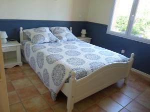 1 Schlafzimmer mit einem Bett mit einer weißen Decke und 2 Fenstern in der Unterkunft Maison Bel Air in Pimbo