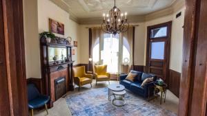 a living room with a blue couch and yellow chairs at Court St Suite in Clarksburg