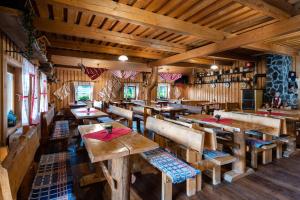 Un restaurante vacío con mesas y bancos de madera. en Chata Homola - Telgárt Resort, en Telgárt