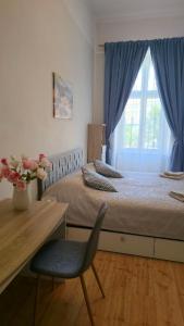 a bedroom with a bed and a chair and a window at Fountain Residence in Sopron