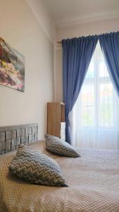 a bedroom with a bed with pillows and a window at Fountain Residence in Sopron