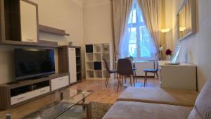 a living room with a couch and a television and a table at Fountain Residence in Sopron +11 photos