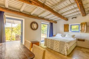 a bedroom with a bed and a table and a window at Barrieiro - Art & Nature in Marvão