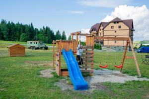 Un niño jugando en un parque infantil con un tobogán. en Chata Homola - Telgárt Resort, en Telgárt