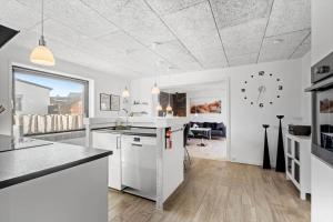 een keuken met witte apparatuur en een woonkamer bij 8811-Hvide-Sande-Vesterhavsvej-3-stuen in Hvide Sande