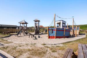 een speeltuin met een glijbaan en een schommel bij 8811-Hvide-Sande-Vesterhavsvej-3-stuen in Hvide Sande