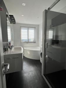 a bathroom with a tub and a sink and a toilet at SeeZeit Friedrichshafen in Friedrichshafen