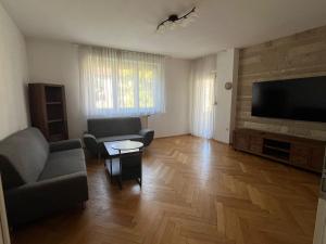 a living room with a couch and a flat screen tv at SeeZeit Friedrichshafen in Friedrichshafen