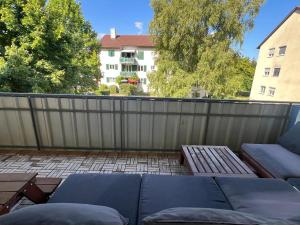 a patio with a fence and a couch and chairs at SeeZeit Friedrichshafen in Friedrichshafen