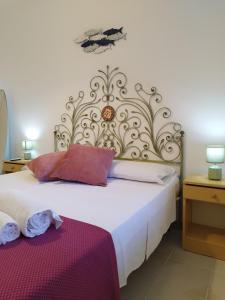 a bedroom with a white bed with a large headboard at Icore a mare IUN T7289 in Cala Gonone