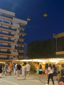 a group of people walking down a street at night at Hotel Unirea in Mamaia