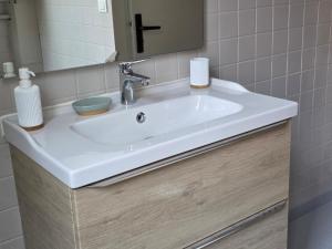 a white sink in a bathroom with a mirror at T2 Cosy Centre ville Clim & Wifi in Aubenas