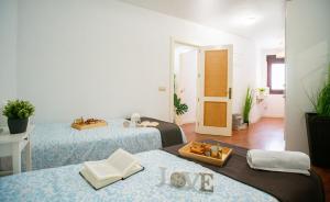 a room with two beds and a table with books at High-End Corner Stay with FREE Parking - Malaga in Málaga