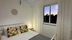 a white bedroom with a bed and a window at Casa do Monte by Check-in Portugal in Albufeira +21 photos