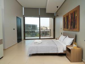 达喀尔Noom Hotel Dakar Sea Plaza, a member of Radisson Individuals的一间带床和大窗户的卧室