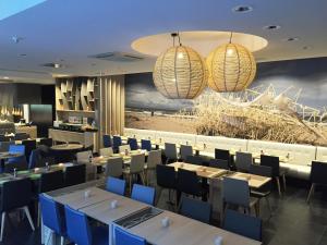 ein Esszimmer mit Tischen und Stühlen und einem Wandgemälde in der Unterkunft Ostend Hotel in Ostende