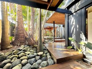 eine Veranda eines Hauses mit Bäumen und Felsen in der Unterkunft Palmaya in Arrawarra