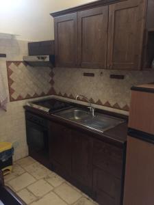 a kitchen with wooden cabinets and a sink at Il Trullo Di Santanna in Locorotondo