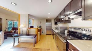 a kitchen with stainless steel appliances and a living room at Crestview Condo 25 in Ketchum