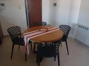 a wooden table with chairs and a bowl of food on it at Paseo de los Poetas in Salta +5 photos