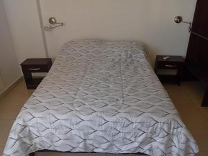 a bed in a room with two nightstands and a bedspread at Paseo de los Poetas in Salta