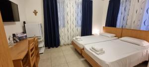 a hotel room with two beds and a television at Rivotorto Retreat House in Birkirkara