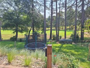 un parco con trampolino sull'erba di Villa neuve 4 ch sur Golf des Pins à Hardelot-Plage a Hardelot-Plage