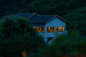 una casa con le luci accese nella foresta di Ethnic Hundred-years Elysian Culture&Art Scholar Resorts a Zhangjiajie