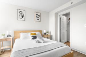 a white bedroom with a large bed and two tables at Pentagon City Escape - Contemporary & Comfy in Arlington