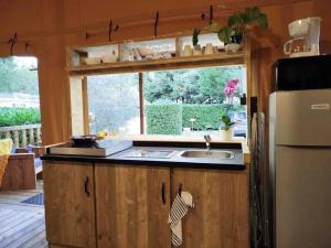 a kitchen with a sink and a refrigerator at Camping 4 étoiles - Piscine - eehf0d in Noves