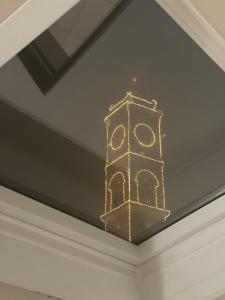 a gold clock on the ceiling of a room at Le Torri Loft, exclusive comfort in the city center in Forlì