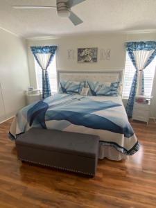 een slaapkamer met een bed en blauwe gordijnen bij Misty falls in Ormond Beach