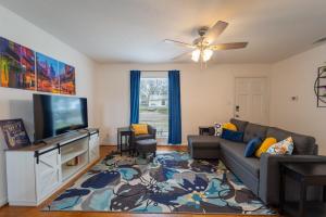 a living room with a couch and a flat screen tv at The Fleur-de-lis in Temple
