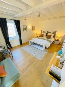 a bedroom with a king sized bed and a living room at Ferme les Chapelles Utah Beach in Angoville-au-Plain