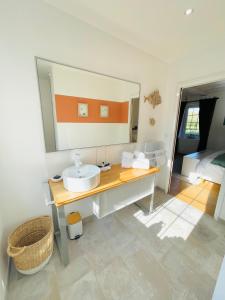 a bathroom with a sink and a large mirror at Ferme les Chapelles Utah Beach in Angoville-au-Plain